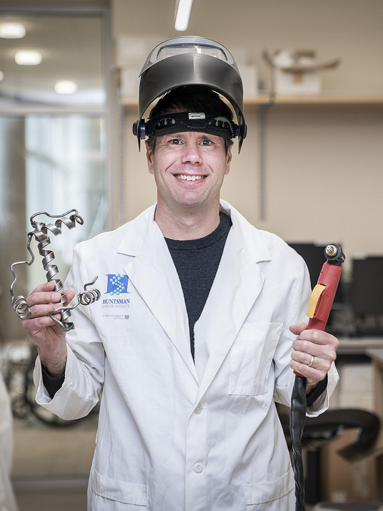 Bryan Welm holding a metal sculpture he made