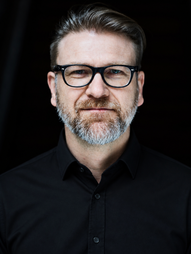 Portrait eines Mannes mit schwarzer Brille und grauem Bart