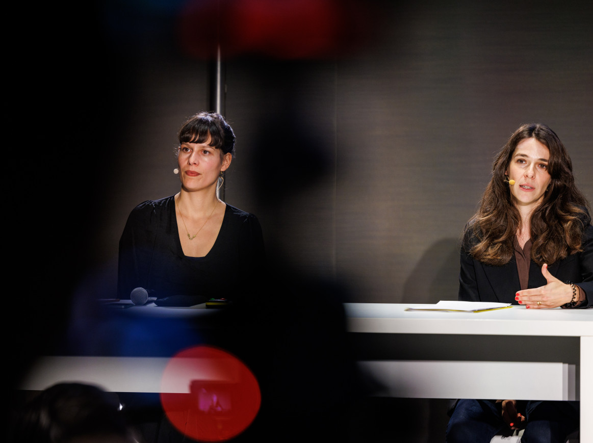 Two women sit on a panel. 