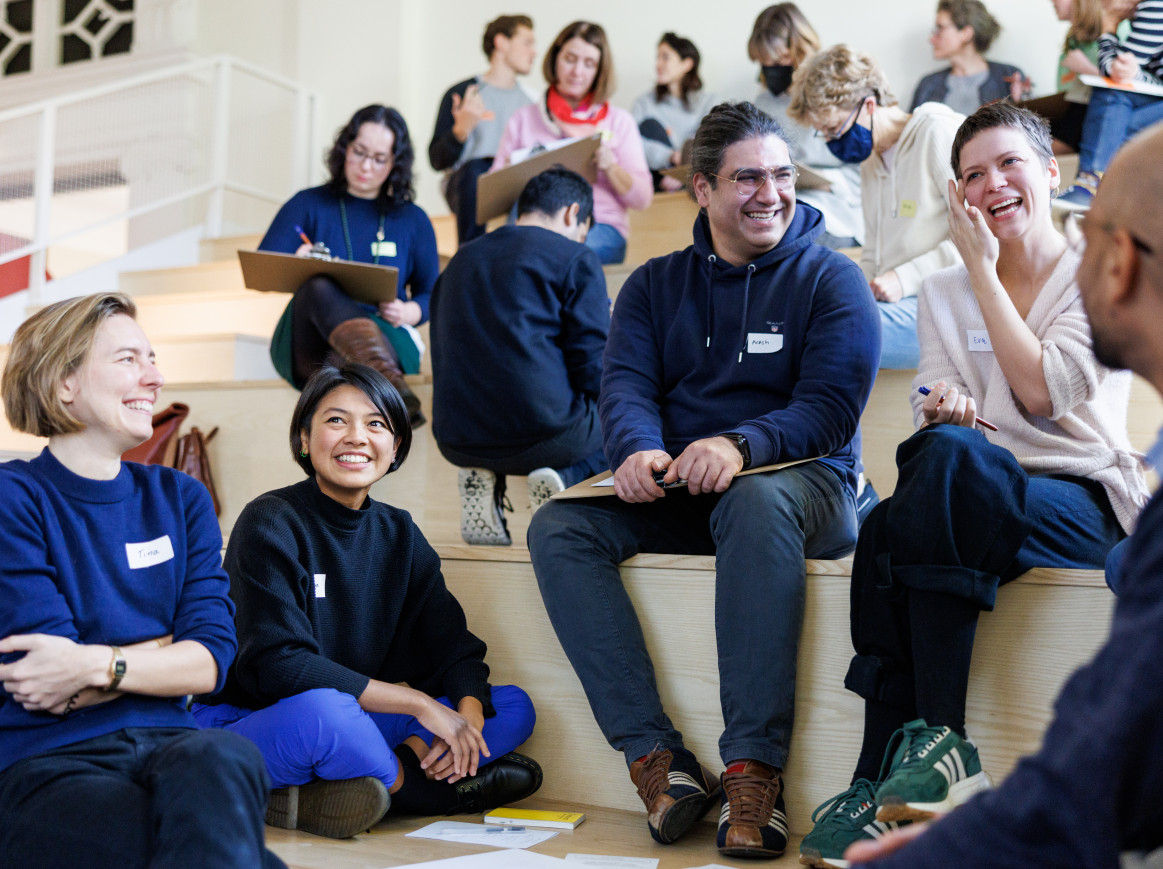A group of people smiles and laughs together. 