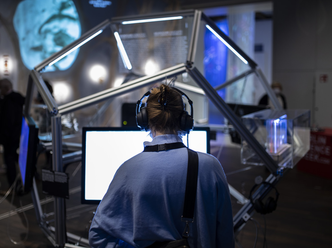 A woman stands in front of an exhibition 
