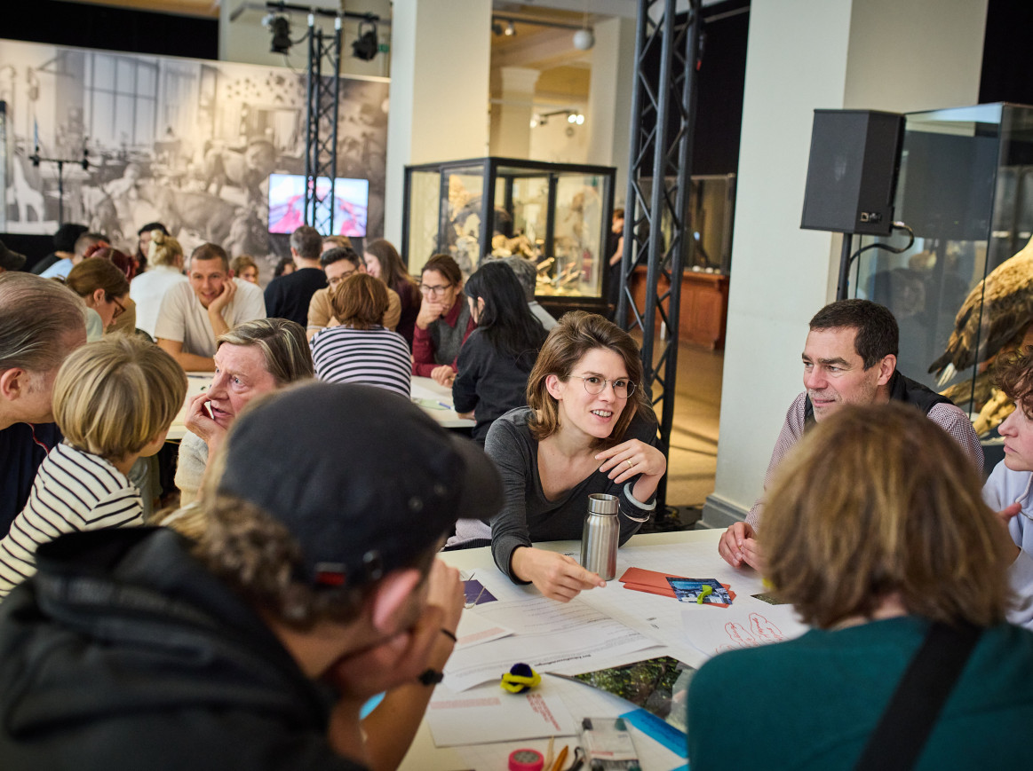 A group of people discuss a topic in a workshop. 