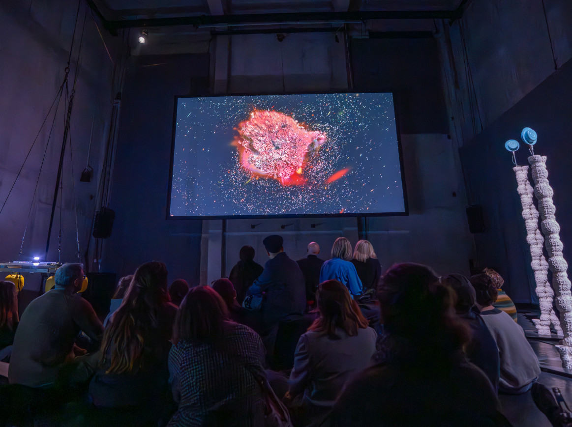 People look up at a screen in an exhibition