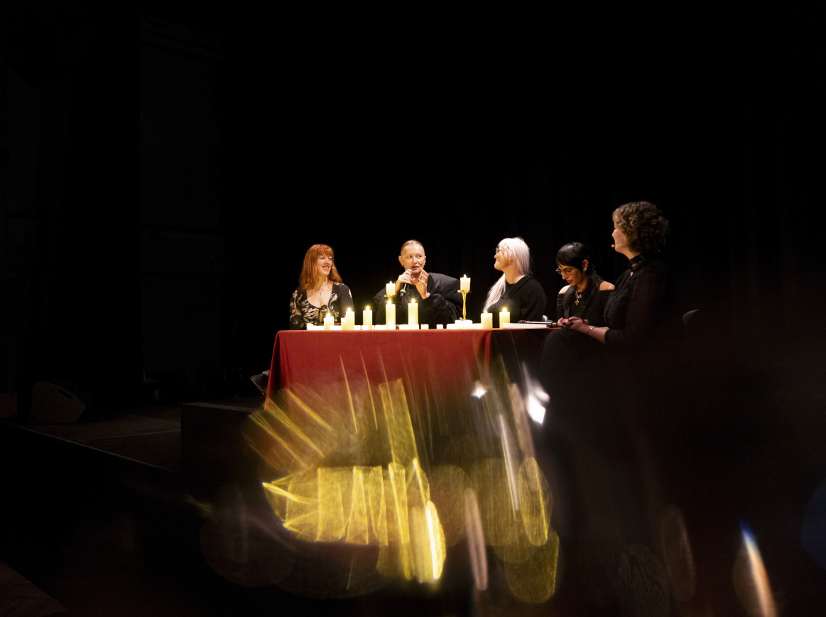 A blurred image in the dark of people sitting at a candlelit table