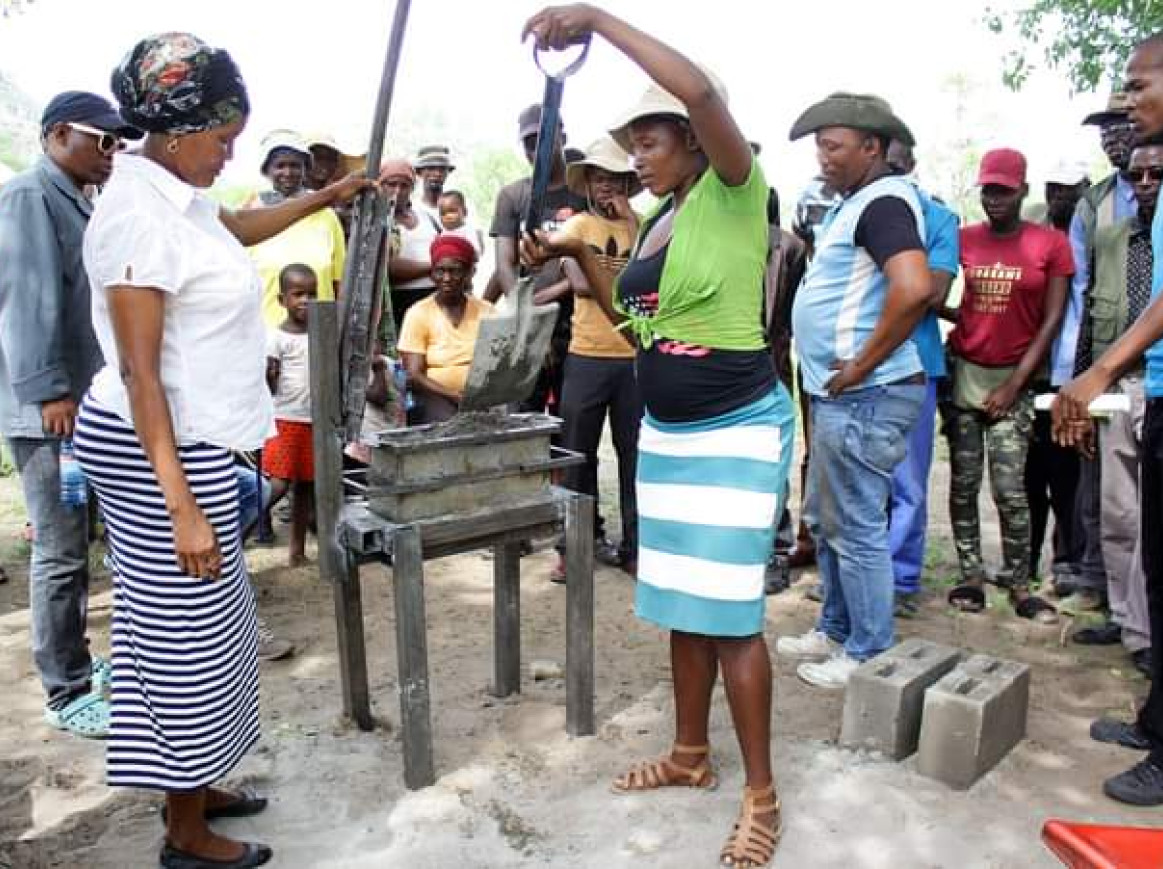 A woman is scooping sand with shovel