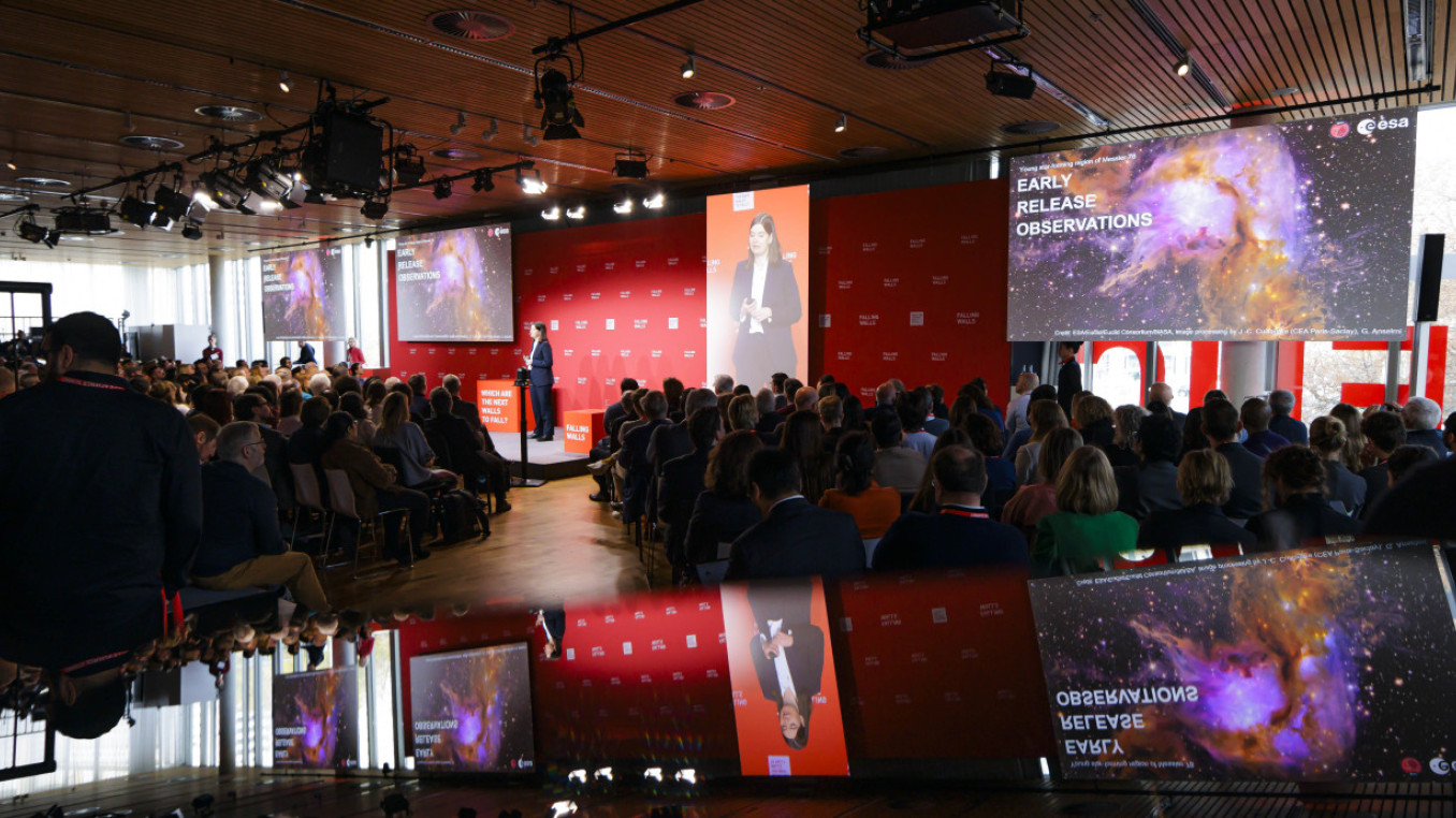 Event room, spotlight on the stage, a lot of people listening