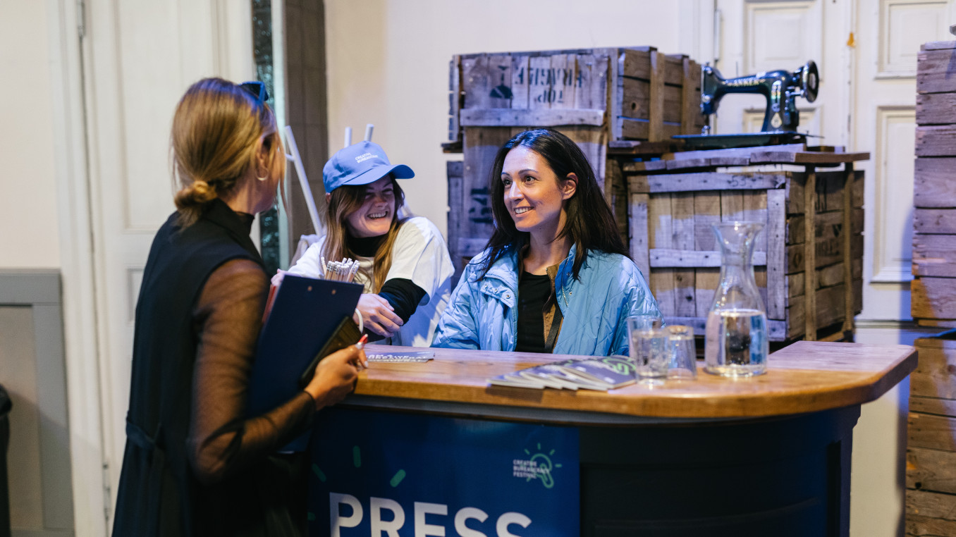 press counter at the festival, 3 woman having a conversation
