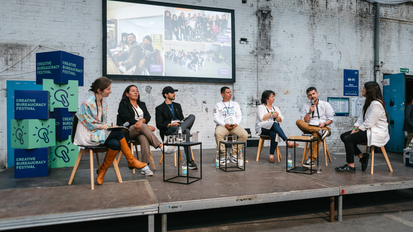 seven speaker sitting on stage and having a discussion 