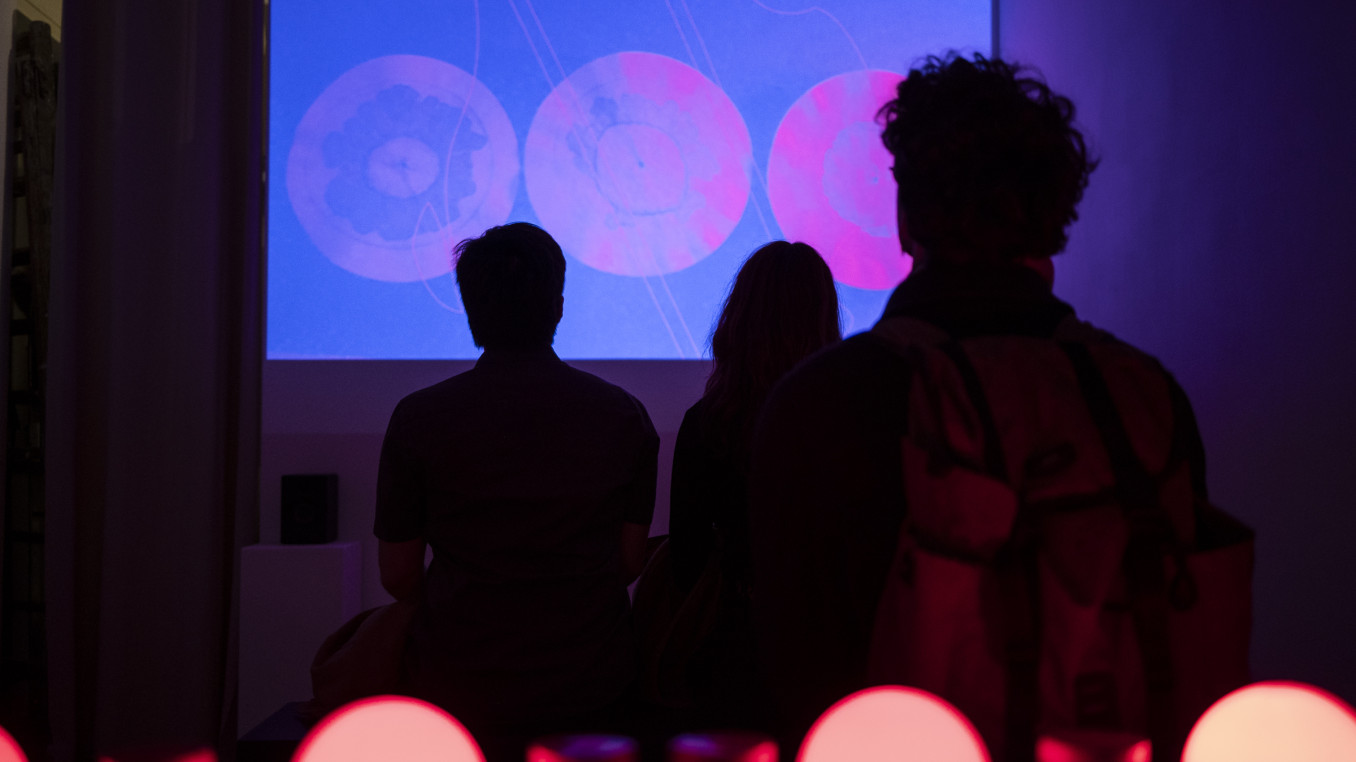 People watch a film in a dark room 