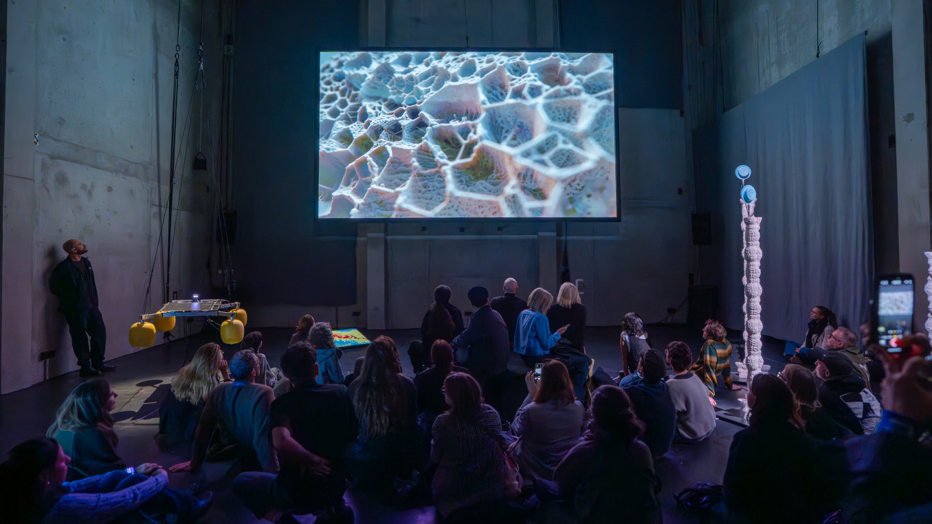 People staring at a huge screen 