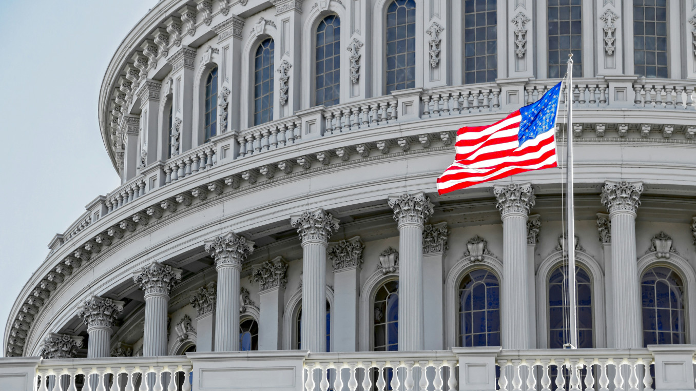 US flag flying on the US Capitol Building