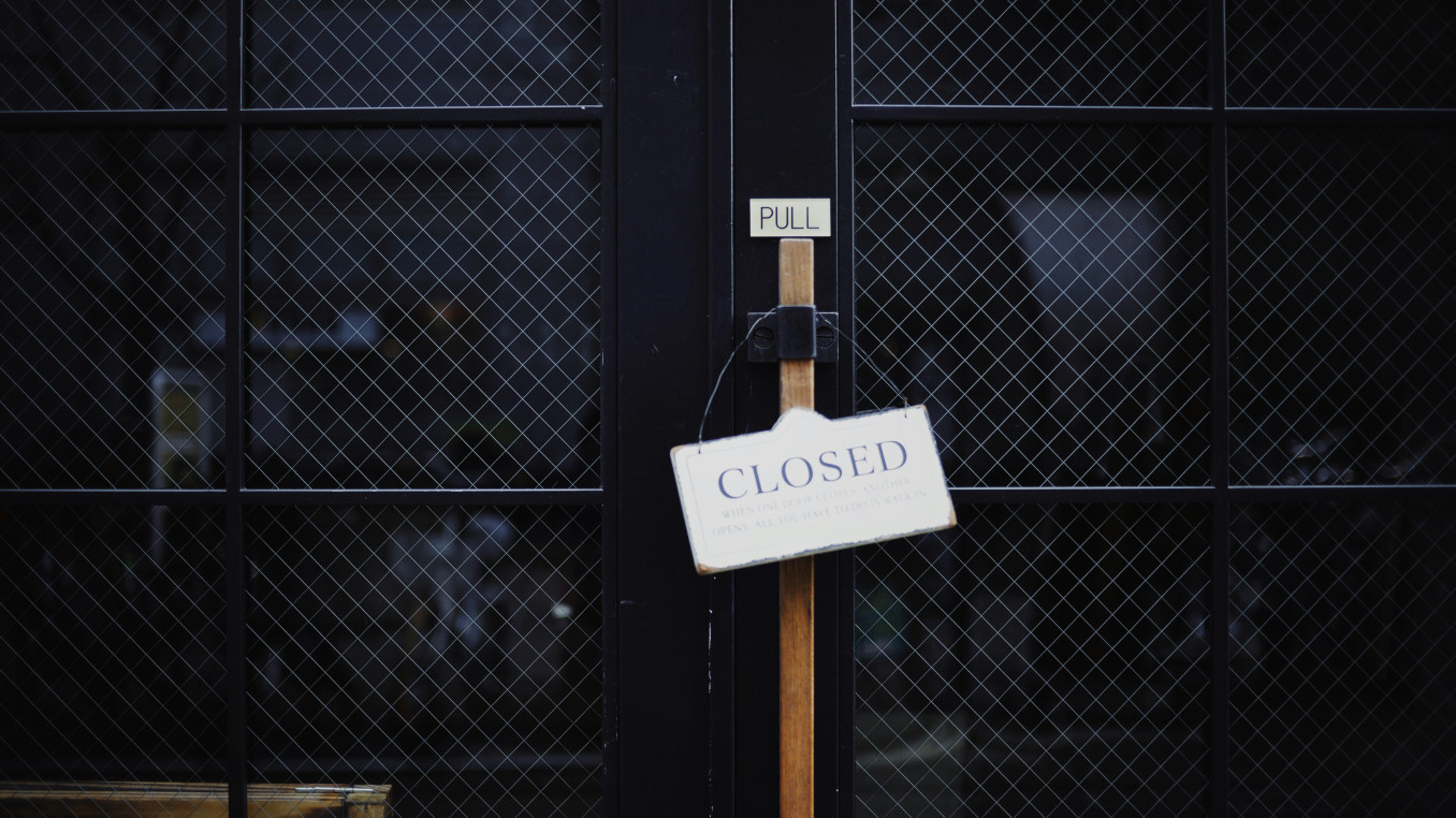 closed black metal door with the sign "closed"