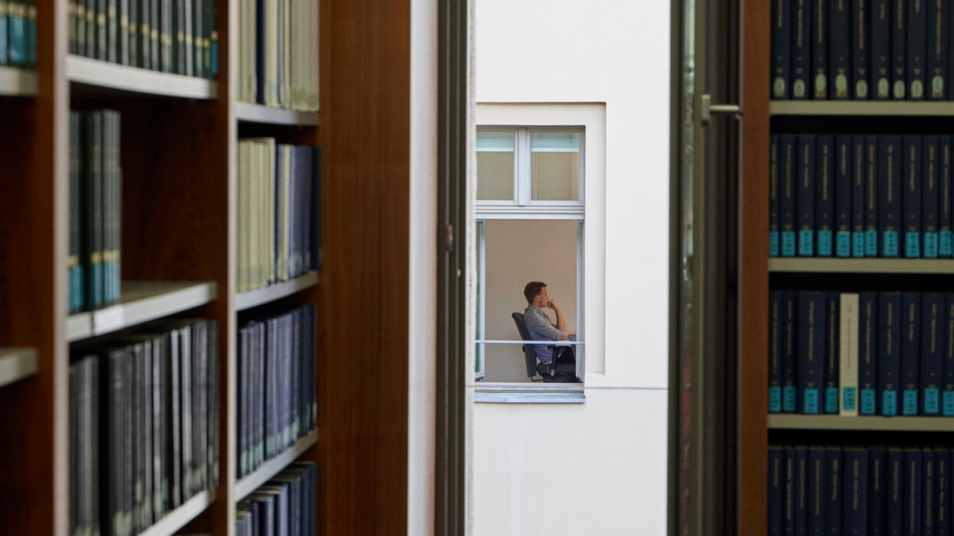 Blick durch ein Fenster auf eine Person